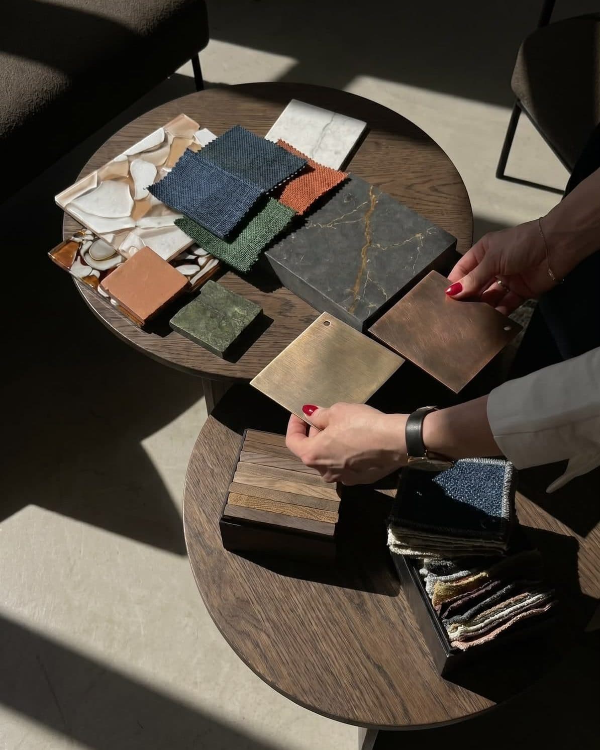 Stone, fabric, timber and metal samples gathered and compared on a table at the start of a scheme