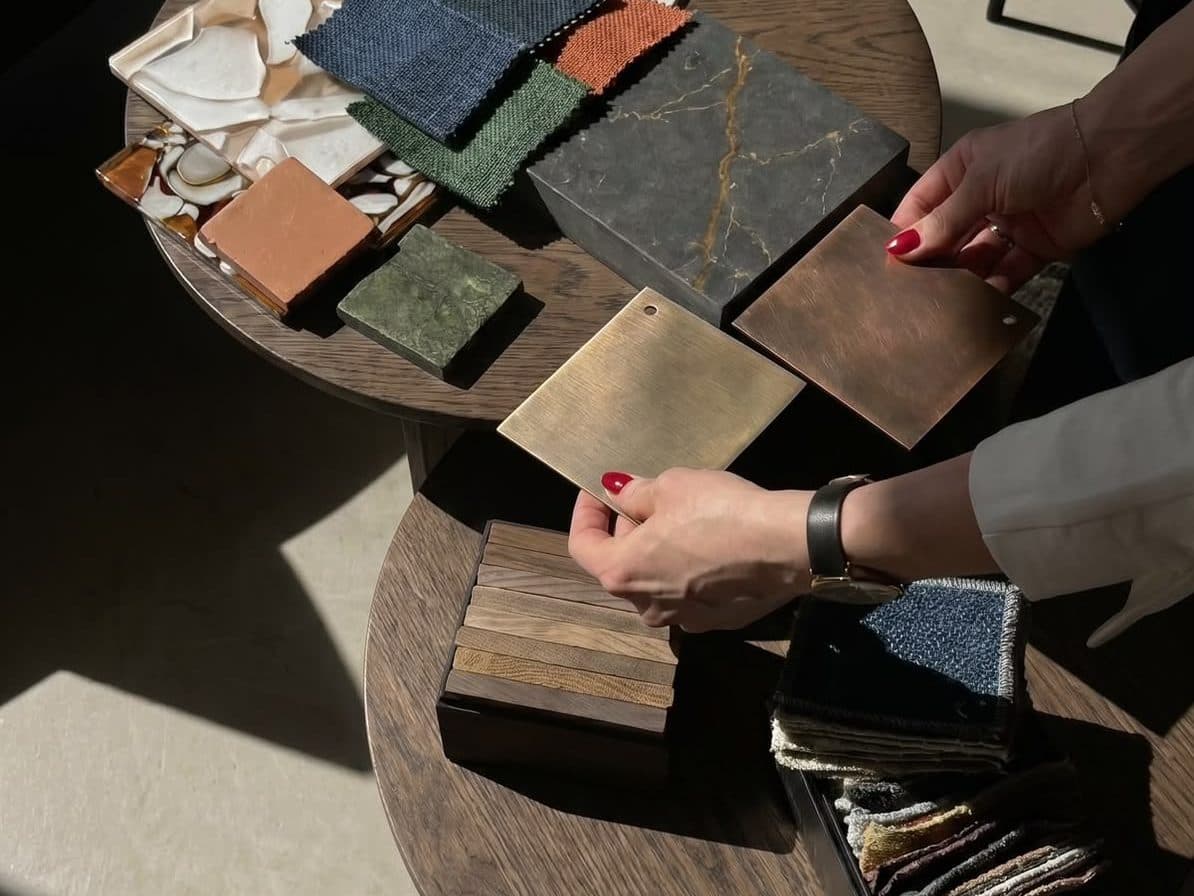Stone, fabric, timber and metal samples laid out on a table while a scheme is chosen